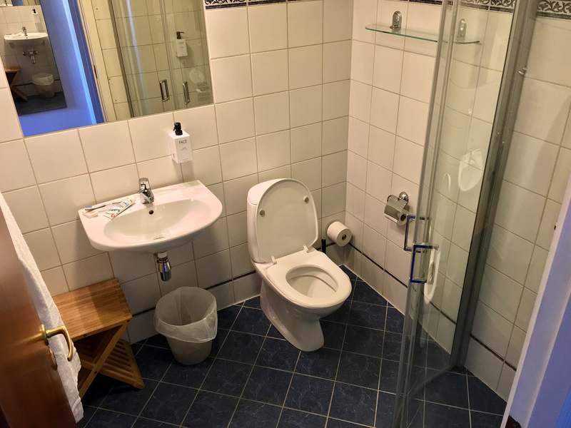 Modern tiled bathroom with a walk in glass shower, basin and toilet