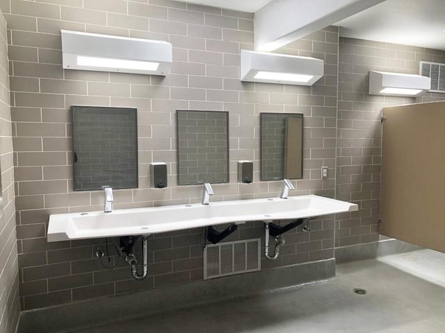 Bathroom with a row of basins, mirrors and tiled walls