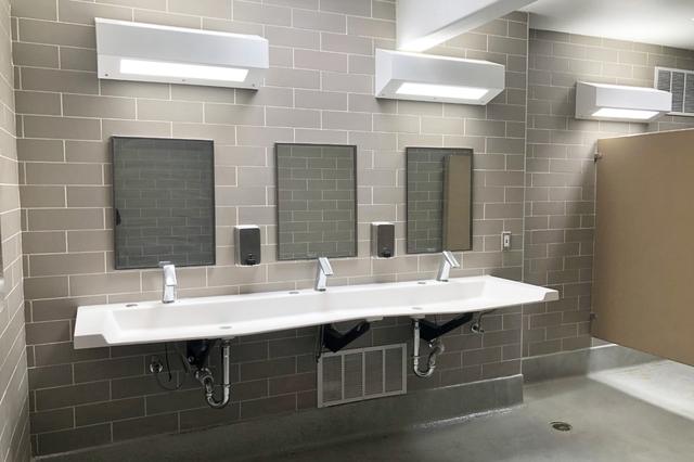 Bathroom with a row of basins, mirrors and tiled walls